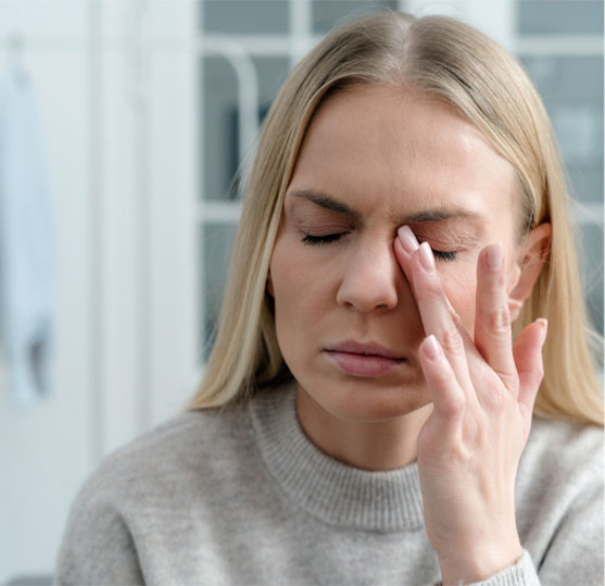 Woman rubbing eye due to dry eye at Alberta Eye Care